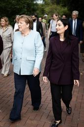 Bundeskanzlerin a.D. Angela Merkel und Bundesministerin Reem Alabali Radovan laufen nebeneinander