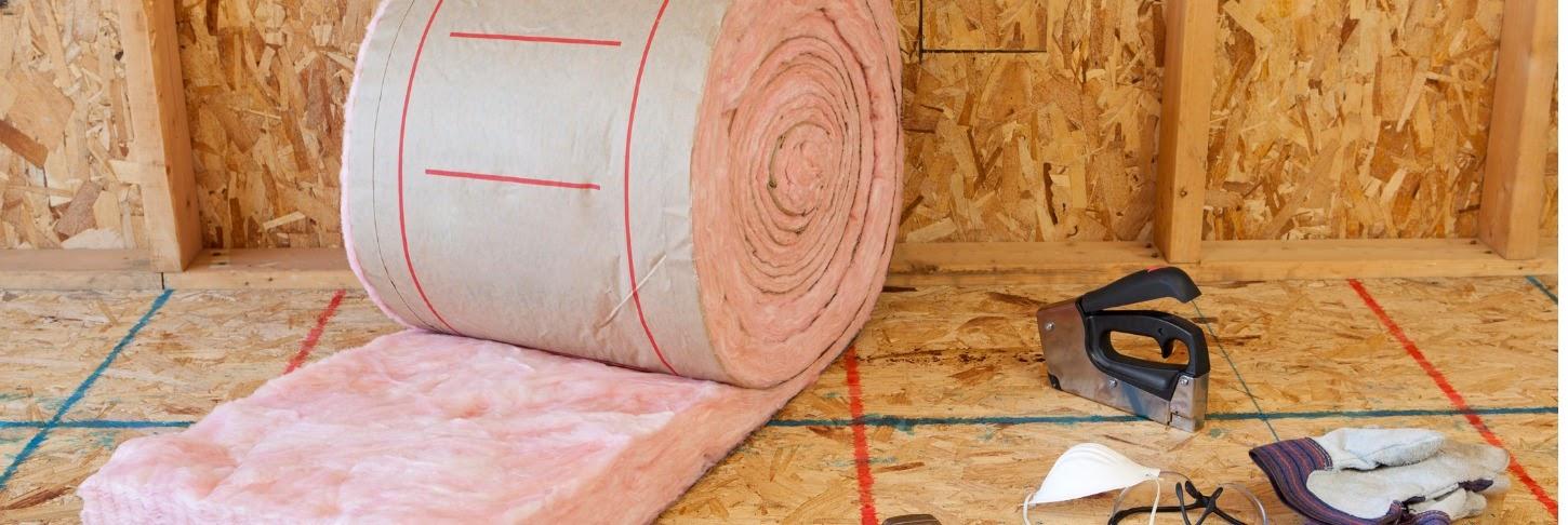 A roll of loft insulation ready to be laid out with a staple gun and dust mask