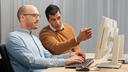 Technical expert educating an in-house engineer from a computer