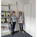 Zwei Bibliotheksmitarbeiterinnen mit einer Stange zum Fensteröffnen
