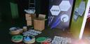 Aufbau einer Ausstellung mit Kartons, runden Display‑Elementen und zwei großen Infotafeln zu Glasfaser und kommunaler Vernetzung. Eine Leiter steht im Hintergrund.