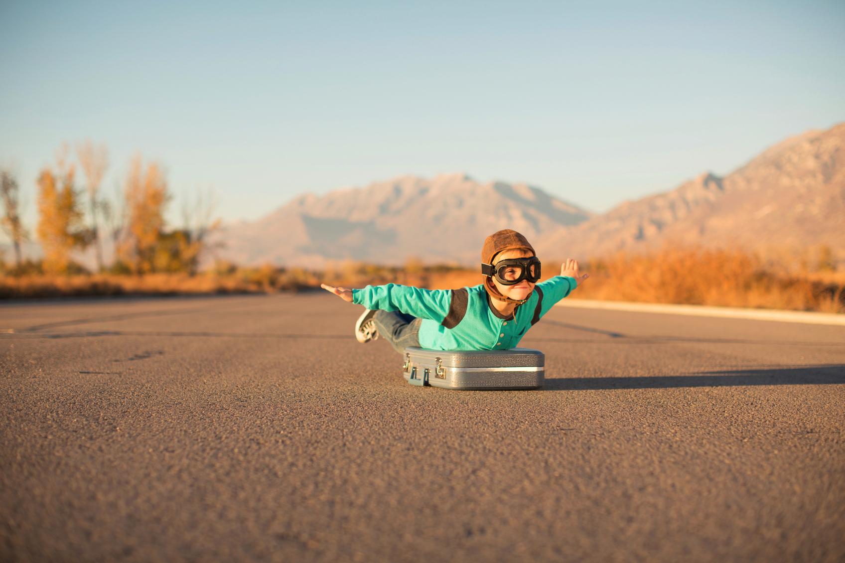 Online Marketing - Der Weg NTII Kind als Pilot verkleidet "fliegt" auf Koffer