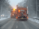 Streufahrzeuge auf einer zugeschneiten Straße im Winter