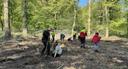 KBK Mitarbeitende pflanzen gemeinsam mit mehreren Mädchen Bäume auf Waldfläche