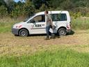 Forstwirtschaftsmeister Reinhard Possberg trägt einen Jungbaum an einem KBK-Auto vorbei
