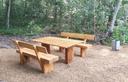 Holzsitzbänke mit Tisch stehen am Waldrand