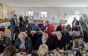 Amphibienhelferinnen und -helfer sitzen an Tischen und essen Kuchen