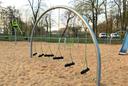 Sandkasten auf Spielplatz mit neuem Spielgerät zum Balancieren und Schaukeln