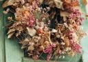 Herbstlicher Kranz auf einer grünen Holztür