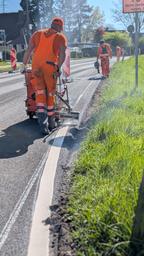 Arbeiter markeiren eine frisch sanierte Straße