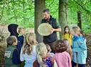 KBK-Förster erklärt Kindern die Jahresringe auf einer Baumscheibe