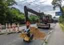 Ein Bagger schaufelt Sand auf einer Straße