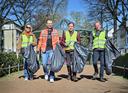 Vier Personen laufen nebeneinander mit Mülltüten und Müllzangen in der Hand beim KBK-CleanUp Day in Krefeld