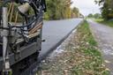 Asphaltiergerät fährt über eine frische Asphaltschicht auf einer Straße