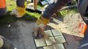 Ein Arbeiter des KBK verlegt neue Stolpersteine an der Grenzstraße in Krefeld