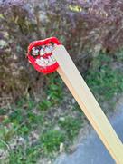 Ein Vampirgebiss wird mit einer Müllzange hochgehalten