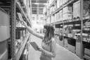 A woman in a warehouse with iPad in her hands