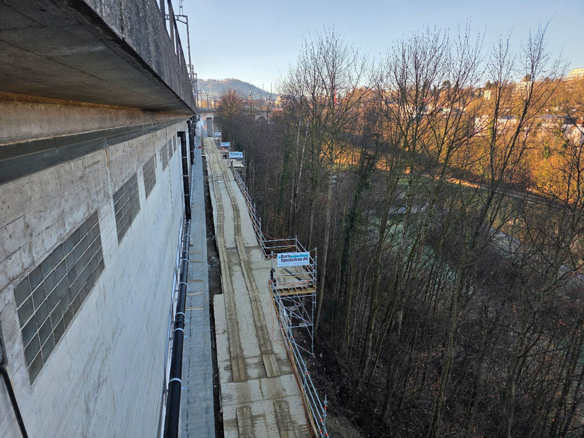 Übersicht der Linienbaustelle entlang des Bahnviadukts in Bern mit schmalem Zugangsweg und Hangbereich.