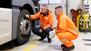 Zwei Kraftfahrer gucken sich etwa an ihrem Reifen an