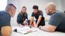 Eine Gruppe von gewerblich-technischen Auszubildenen arbeiten zusammen an einem Projekt