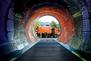 Blick durch einen Tunnel auf ein Müllfahrzeug mit der Aufschrift "Oh happy way!"