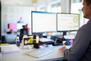 Person sitzt am Schreibtisch und arbeitet