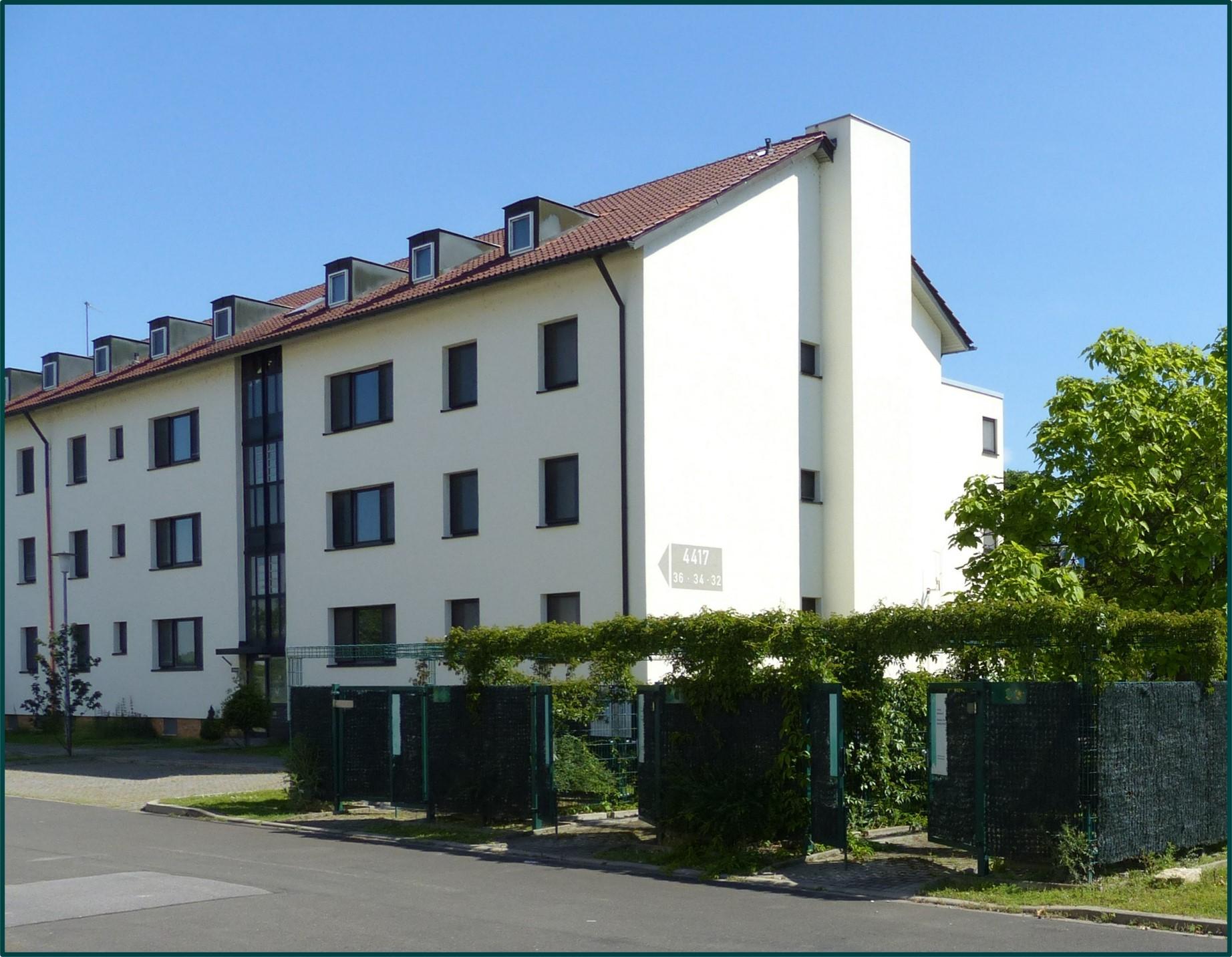 Foto eines regulären Wohnblocks mit drei Etagen und Dachgeschoß