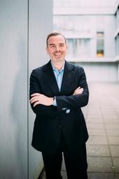 Sébastien Valy, Geschäftsführer von Arval Deutschland, trägt einen Anzug und Hemd und lächelt in die Kamera.