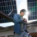 Mann steht unter einer Photovoltaikanlage