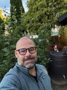 Mann mit Brille vor einem Baum