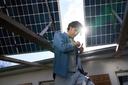 Ein Mann steht unter der Solaranlage seines Hauses