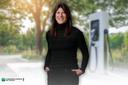 Im Vordergrund ist Astrid Drechsel-Grau in lachelnder Pose zu erkennen. Sie ist die Protagonistin in unserem Selbsttest. Im Hintergrund ist eine Ladesäule für Elektroautos mit ein paar Bäumen abgebildet.