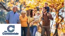 A group of two women and two men and two little children are walking in the nature. One woman is holding a child n her arms and a man has one child on his shoulders with clientlogo Contnentale.