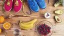 Running shoes and healthy food composition on wooden background