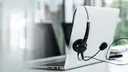 Unfolded laptop with a headset hanging over it