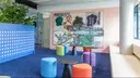 New workspaces at the Thieme site in Stuttgart. Colorful stools stand around small tables in front of a large modern painting.