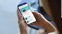Hands holding a smartphone with the Thieme TeleCoach app open