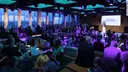 Gäste des DMEA Empfangs im Innenraum der rBB Dachlounge blicken zur Bühne mit Katrin Siems
