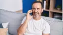 Elderly man talking on the phone on his sofa
