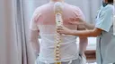 nurse holding spine model against the patients backs