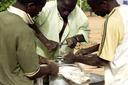 Three men in Africa are working on a technical device.