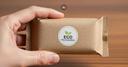 Nachhaltige Verpackung Eine Hand, die eine nachhaltige Verpackung mit der Aufschrift "Eco Packaging" in der Hand hält (KI Generiert)