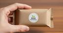 Eine Hand, die eine nachhaltige Verpackung mit der Aufschrift "Eco Packaging" in der Hand hält
