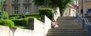Eine Person sitzt auf einer Treppe in der Bayreuther Innenstadt und liest.
