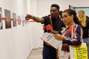 Ein Mann zeigt einer Frau etwas auf einem Bild in der Foto-Ausstellung