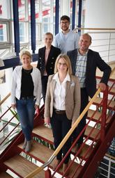 Das Team von Tiho auf einer Treppe