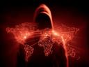 A hooded figure looms ominously against a backdrop of a digitally rendered world map pulsating with interconnected nodes, evoking a sense of cyber espionage and international peril