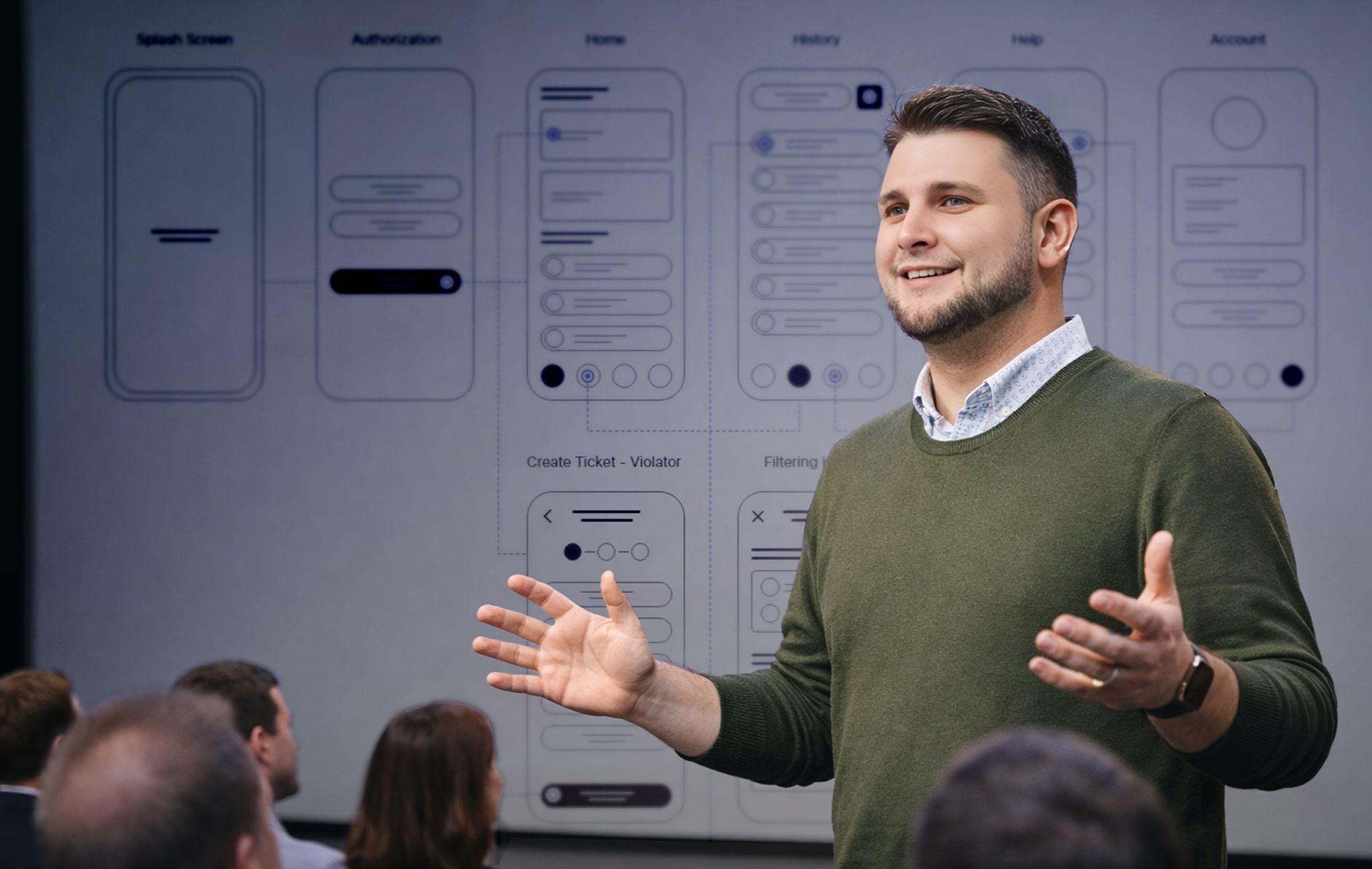 Nicholas Schulz erläutert vor Publikum digitale Antragsstrecken; im Hintergrund sind Wireframes mehrerer Formular- und Prozessschritte zu sehen.