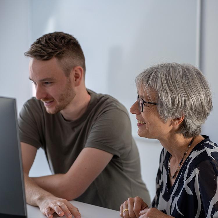 Pinuts-Mitarbeiter betrachten etwas am Computer