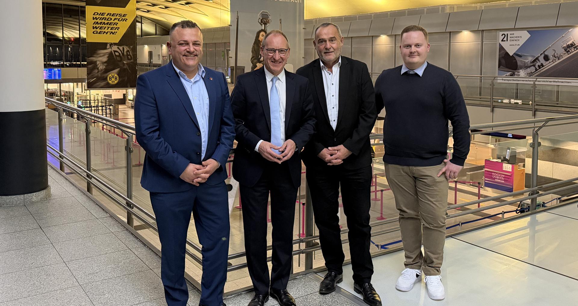 Die neu gewählten Aufsichtsratsvorsitzenden des Dortmunder Flughafens stehen auf der Galerie des Flughafen-Terminals